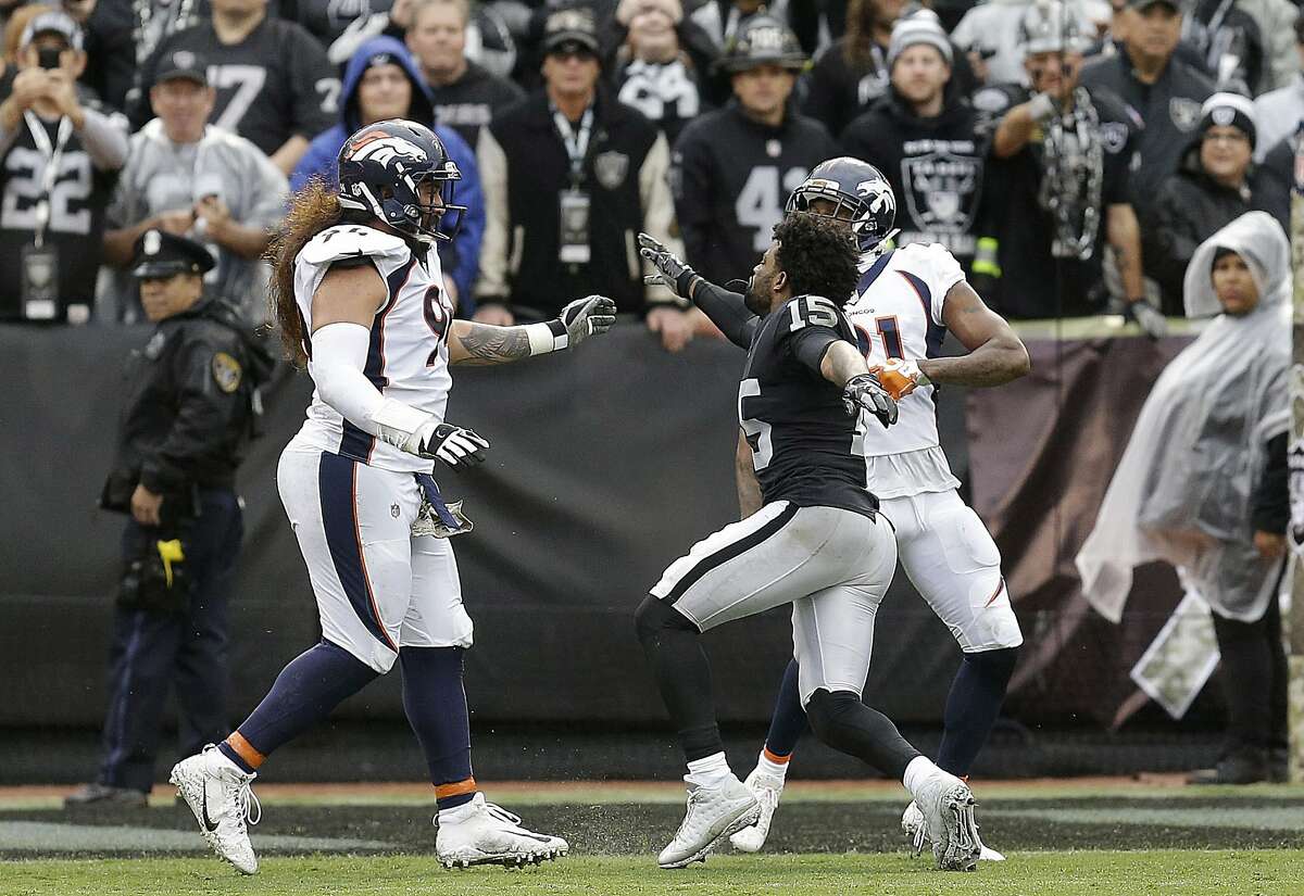 Oakland Raiders wide receiver Michael Crabtree, center, fights with Denver Broncos nose tackle Domata Peko, left, and cornerback Aqib Talib during the first half of an NFL football game in Oakland, Calif., Sunday, Nov. 26, 2017. Crabtree and Talib were ejected. 