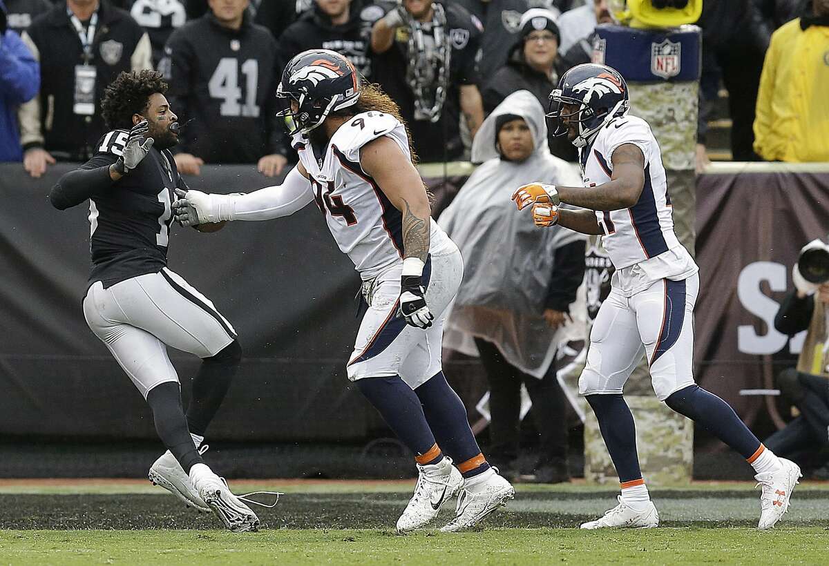 Oakland Raiders wide receiver Michael Crabtree, left, fights with Denver Broncos nose tackle Domata Peko, center, and cornerback Aqib Talib during the first half of an NFL football game in Oakland, Calif., Sunday, Nov. 26, 2017. Crabtree and Talib were ejected. (AP Photo/Ben Margot)