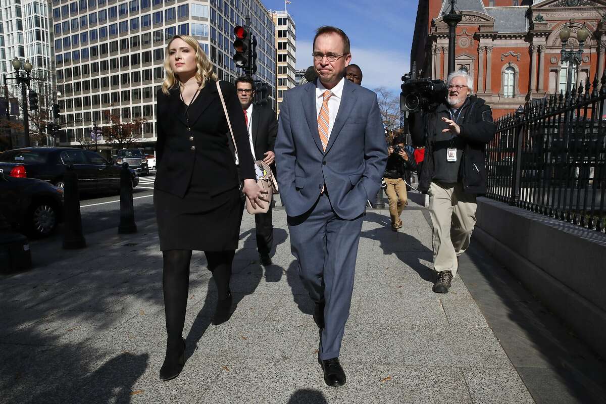 Mick Mulvaney, center, walks to the Eisenhower Executive Office Building after leaving the Consumer Financial Protection Bureau in Washington, Monday morning, Nov. 27, 2017. (AP Photo/Jacquelyn Martin)