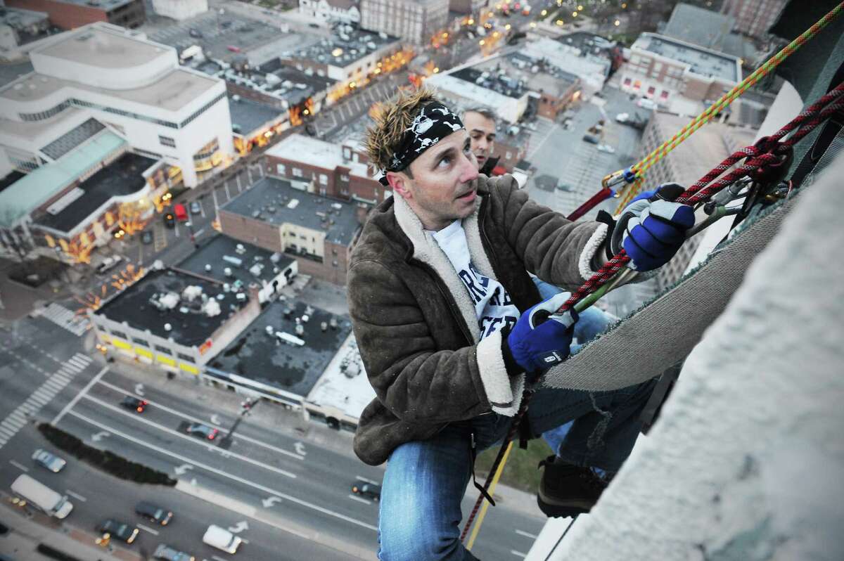 Brian Cashman, the New York Yankees general manager, rappels off the 350-foot Landmark Square in preparation for Sunday's 'Heights and Lights' celebration in Stamford on Friday. Behind Cashman is climber Brian Van Orsdel.