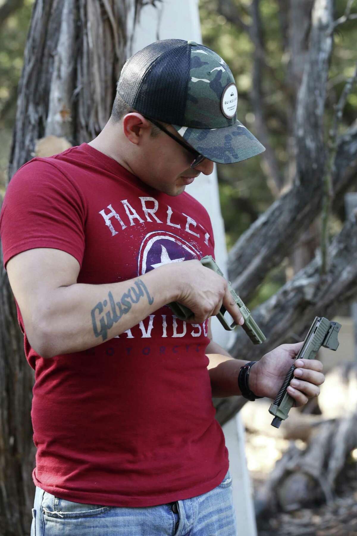 U.S. Marine veteran Justin Bernal, 26, checks out a handgun at Viking Endeavor's in Mico, Texas, Sunday, Oct. 8, 2017.