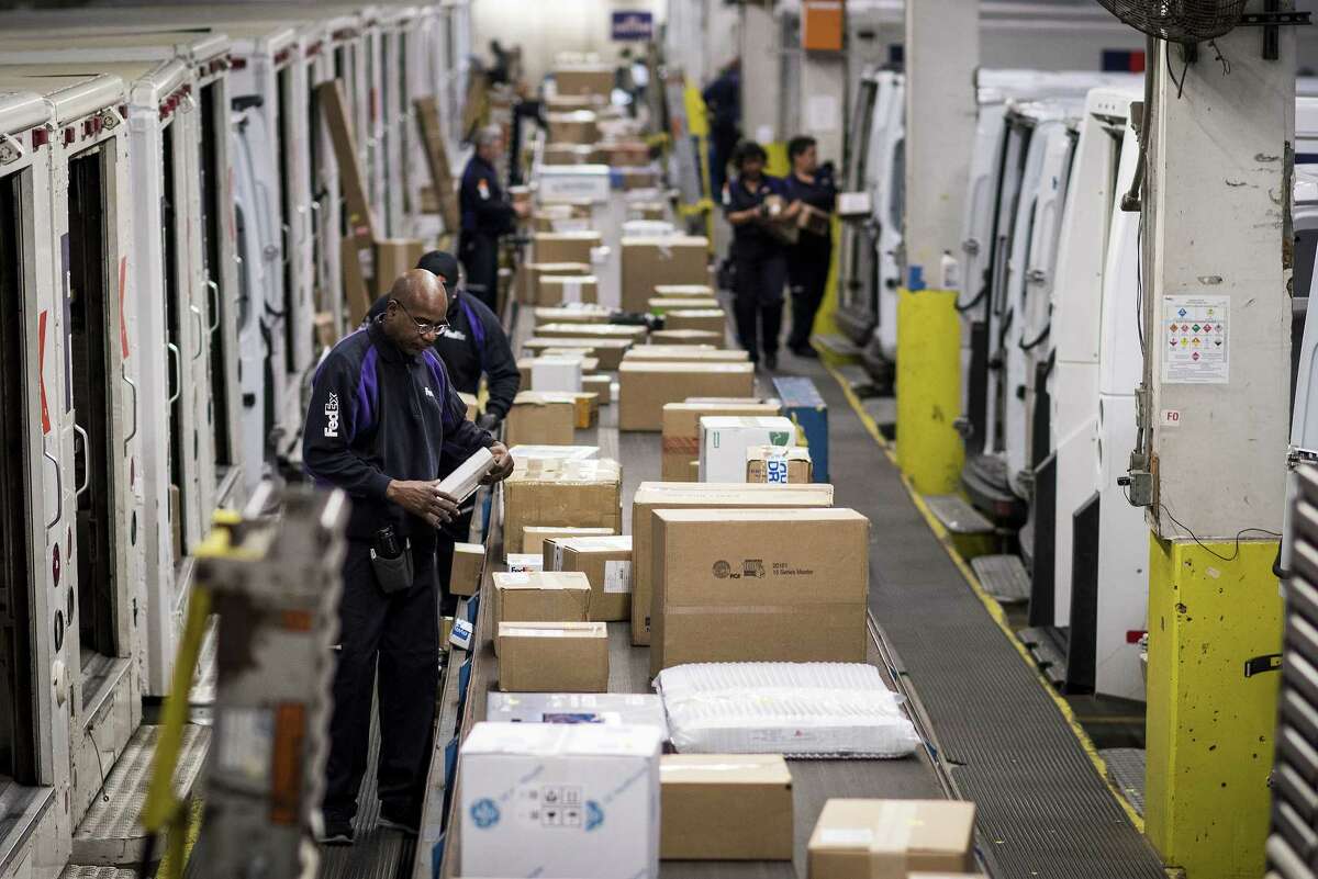 Employees sort packages for delivery on Monday at a FedEx shipping center in Chicago amid growth in online shopping.
