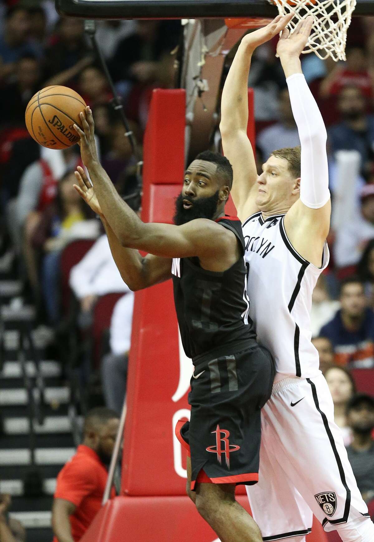 Houston Rockets guard James Harden, left, passes the ball as Brooklyn Nets center Timofey Mozgov defends during the second half of an NBA basketball game, Monday, Nov. 27, 2017, in Houston. Houston won the game 117-103. (AP Photo/Eric Christian Smith)