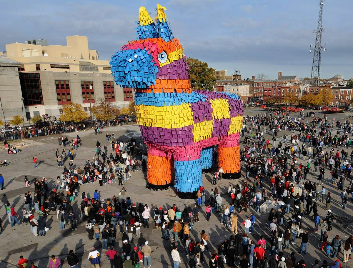 In this handout image supplied by Carnival Cruise Lines, film extras surround a huge pinata, which has broken the Guinness Record for the world's largest pinata, on November 2, 2008 in Philadelphia, Pennsylvania. The giant mock donkey measures 60 feet, 4 inches long; 23 feet, 10.5 inches wide and 61 feet, 10.25 inches tall and is filled with 8,000 pounds of candy. A wrecking ball will be used later on Sunday to smash the pinata during a public event.