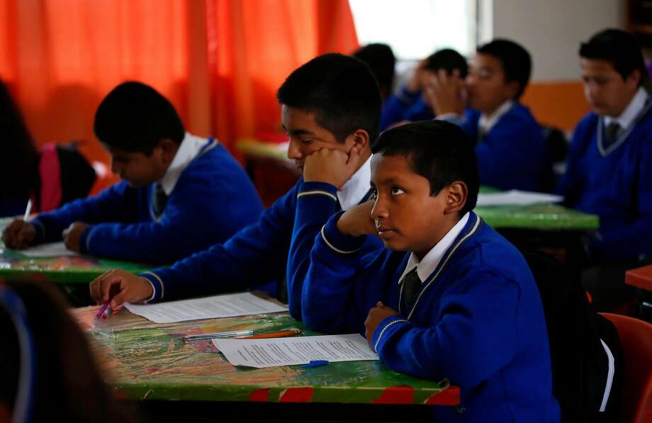 Jesus Sanchez, 12, right, listens to the teacher read literature with his cousin Francisco Mejia, 13, left center, at school Oct. 2, 2017 in Santa Monica, Hidalgo, Mexico. School has been very difficult for Jesus to adjust to because Spanish is not his first language and the teacher is much more strict than US teachers are allowed to be. Photo: Leah Millis, The Chronicle