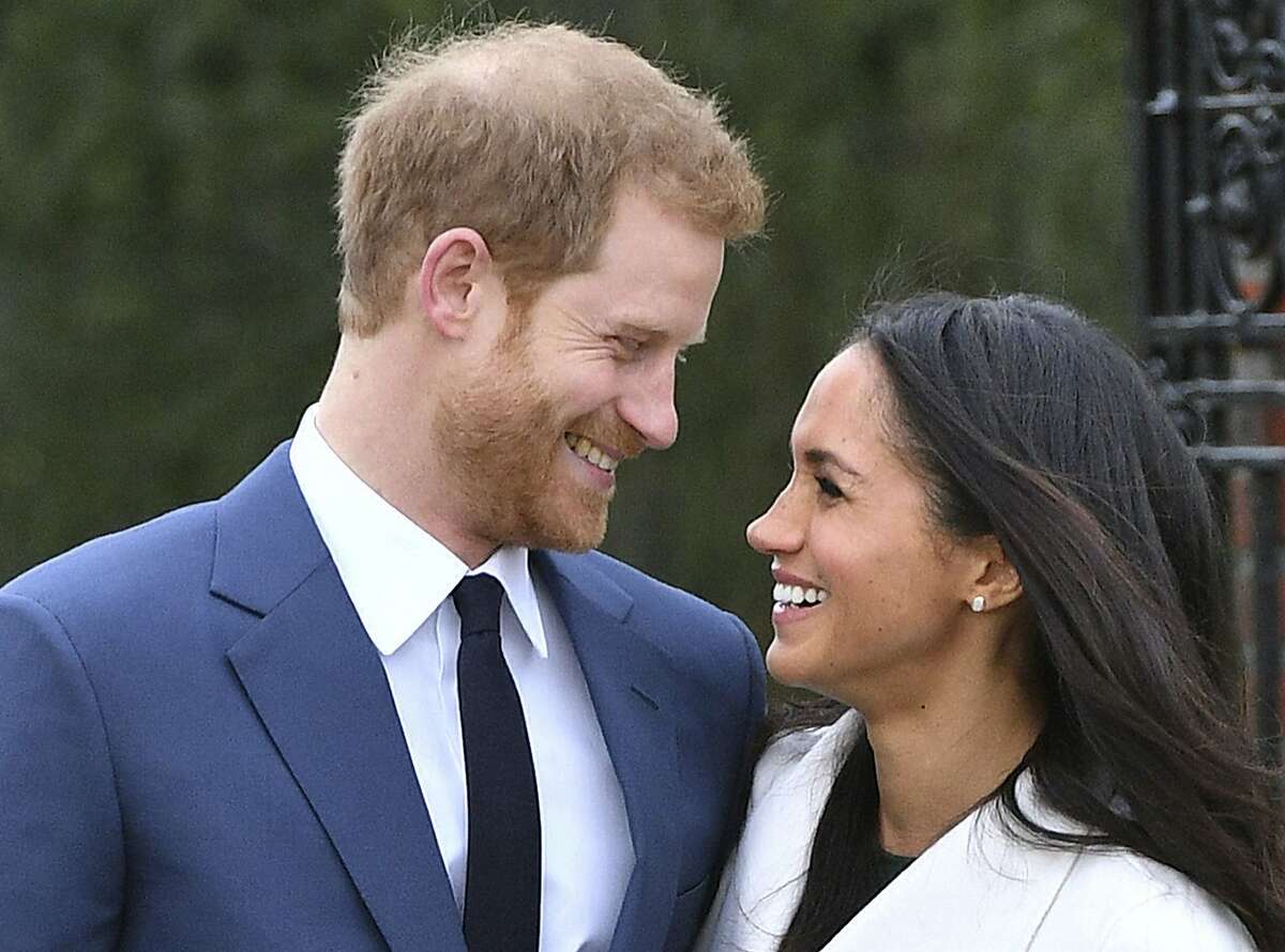 Britain's Prince Harry and Meghan Markle smile as they pose for the media in the grounds of Kensington Palace in London, Monday Nov. 27, 2017. It was announced Monday that Prince Harry, fifth in line for the British throne, will marry American actress Meghan Markle in the spring, confirming months of rumors. (Dominic Lipinski/PA via AP)