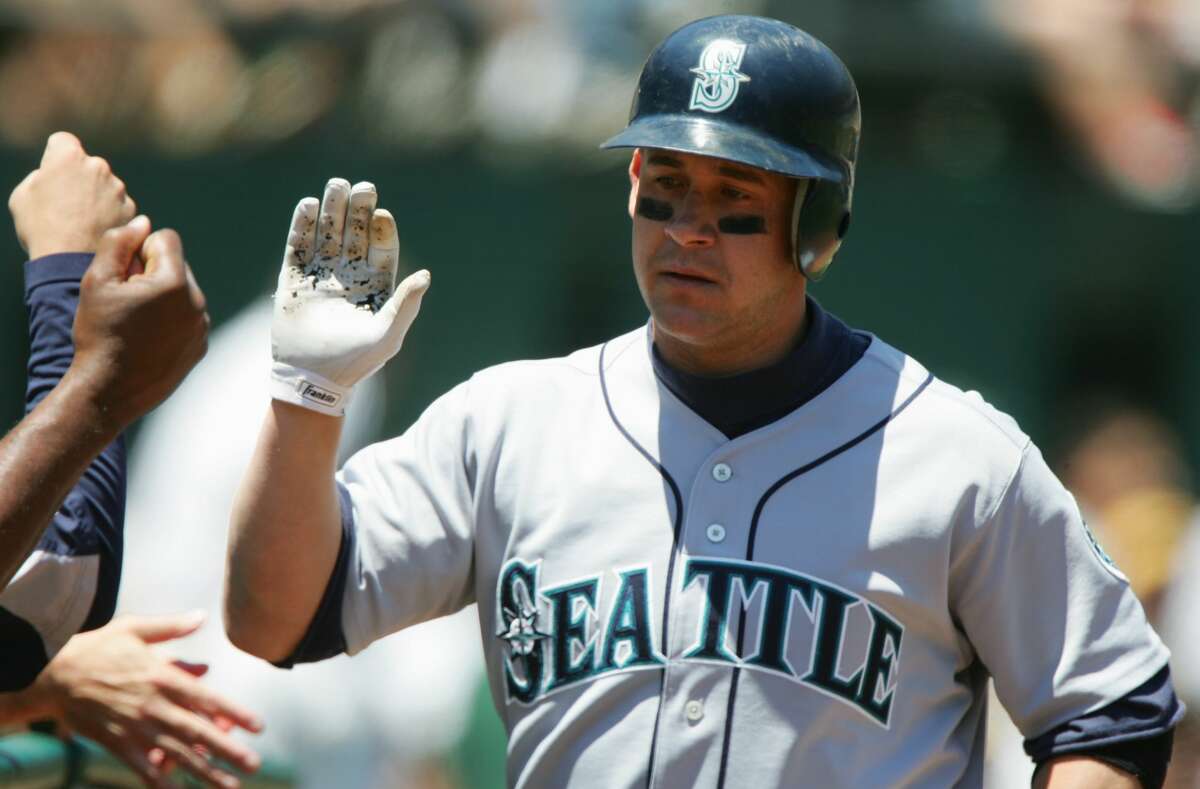 Bret Boone of the Seattle Mariners high fives teammates during an MLB game against the Oakland Athletics at McAfee Coliseum on June 30, 2005 in Oakland, California.