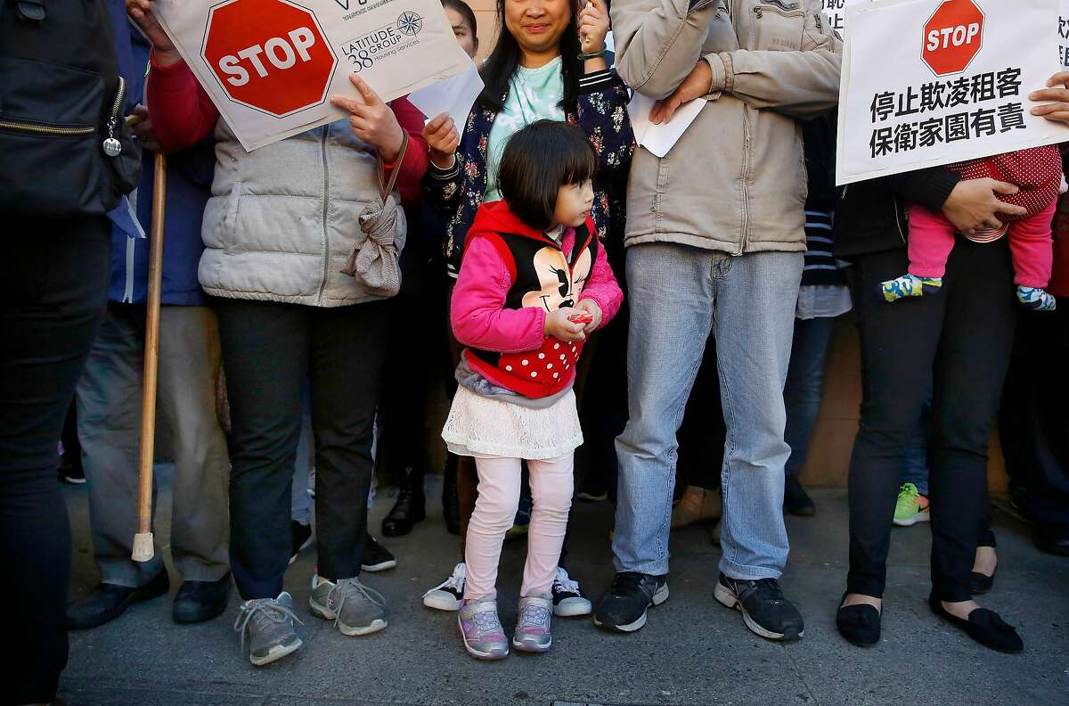 Shirley Chen, 4, stands with her mother as they attend a rally outside 1350 Stockton on Wednesday, November 29, 2017 in San Francisco, Calif. Today a coalition of tenant, civl rights, and community organizations announced a campaign to protect tenants against intimidation, evictions, and increasing rents in Chinatown.