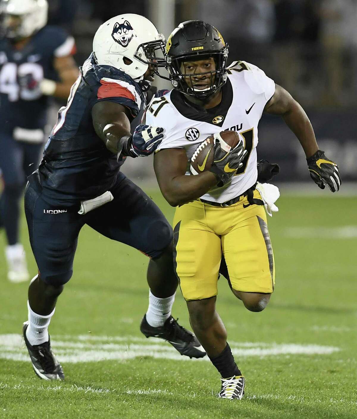 Missouri running back Ish Witter, right, is pursued by Connecticut linebacker Junior Joseph, left, during the first half of an NCAA college football game, Saturday, Oct. 28, 2017, in East Hartford, Conn. (AP Photo/Jessica Hill)