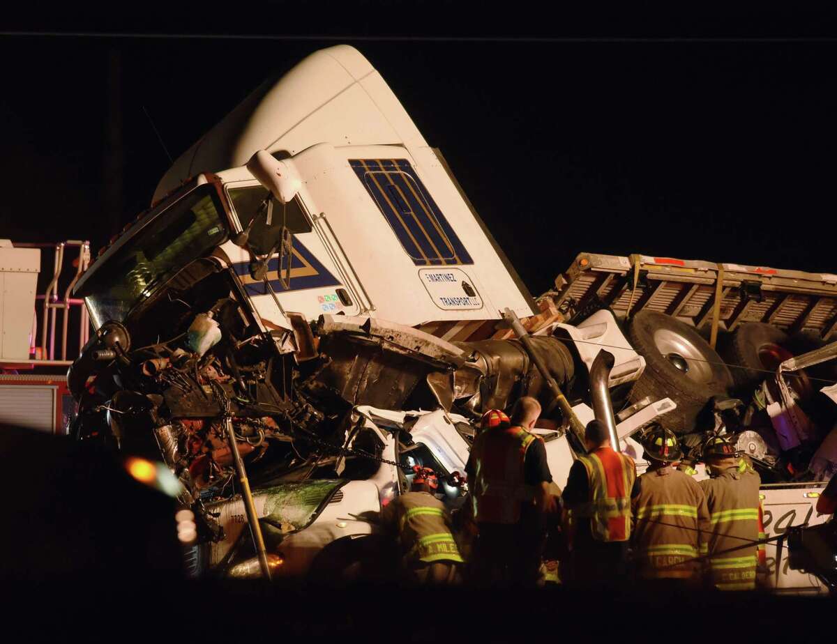 A tractor trailer rests atop a vehicle on Interstate 35 South at Somerset Road on San Antonio on Wednesday, Nov. 29, 2017. One person is known dead in the accident.