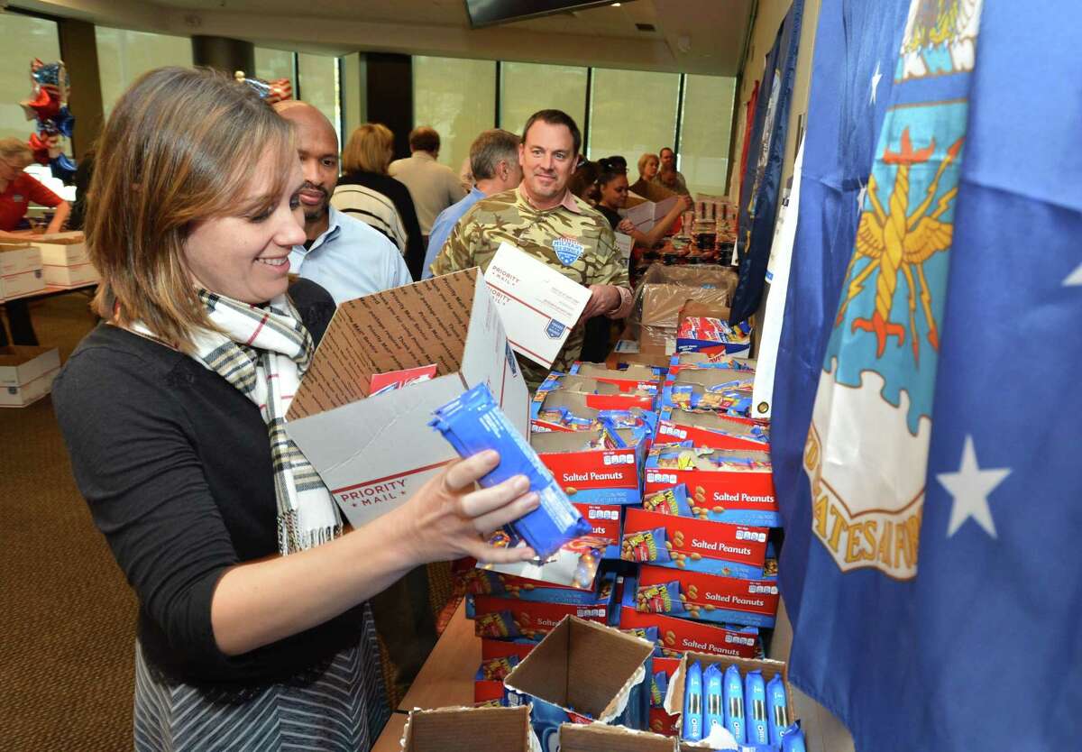 Christine McCord, a manager in the Norwalk, Conn. headquarters of Diageo North America, grabs some cookies to add to the box she is filling in early November 2017 during Military Appreciation Day at the company’s headquarters in Norwalk, Conn. Click through to take a look at Connecticut's breweries. 