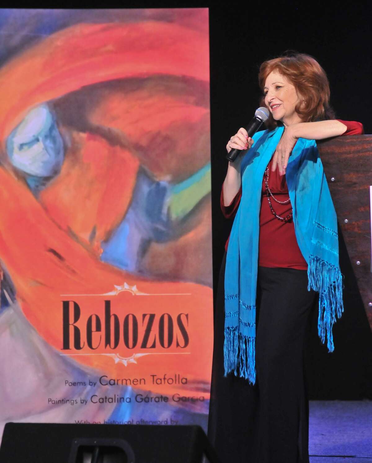 San Antonio author and poet Laureate Carmen Tafolla spoke in front of an enlargement of her book “Rebozos” during a children’s book event.