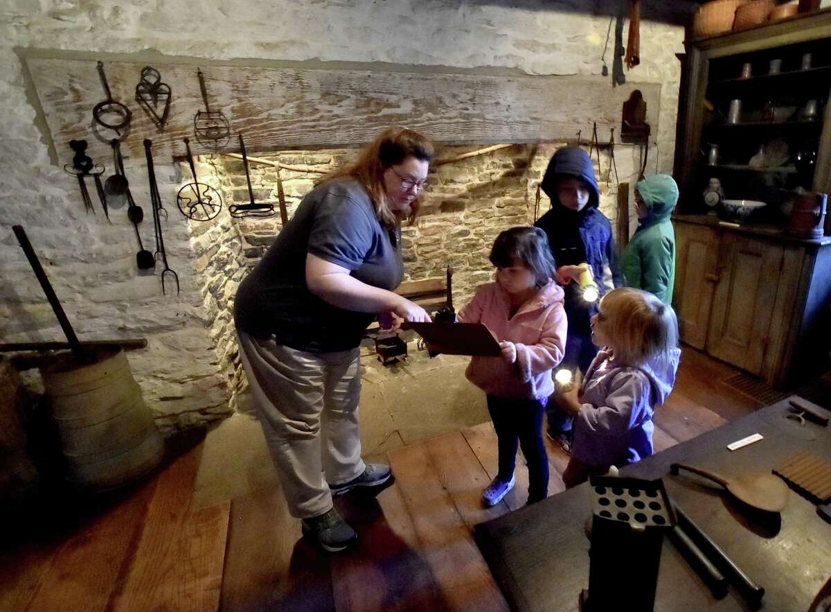 Guilford, Connecticut - Friday, November 24, 2017: Museum curator Michelle Parrish helps, Emily Murphy of Monroe, 4, and her siblings Vincent, 7, Abigail, 3, and Alexander, 6, left to right, with finding objects for a scavenger hunt during Harvesting History Day Friday at the Henry Whitfield State Museum's Whitfield House in Guilford, New England's Oldest Stone House built in 1639.