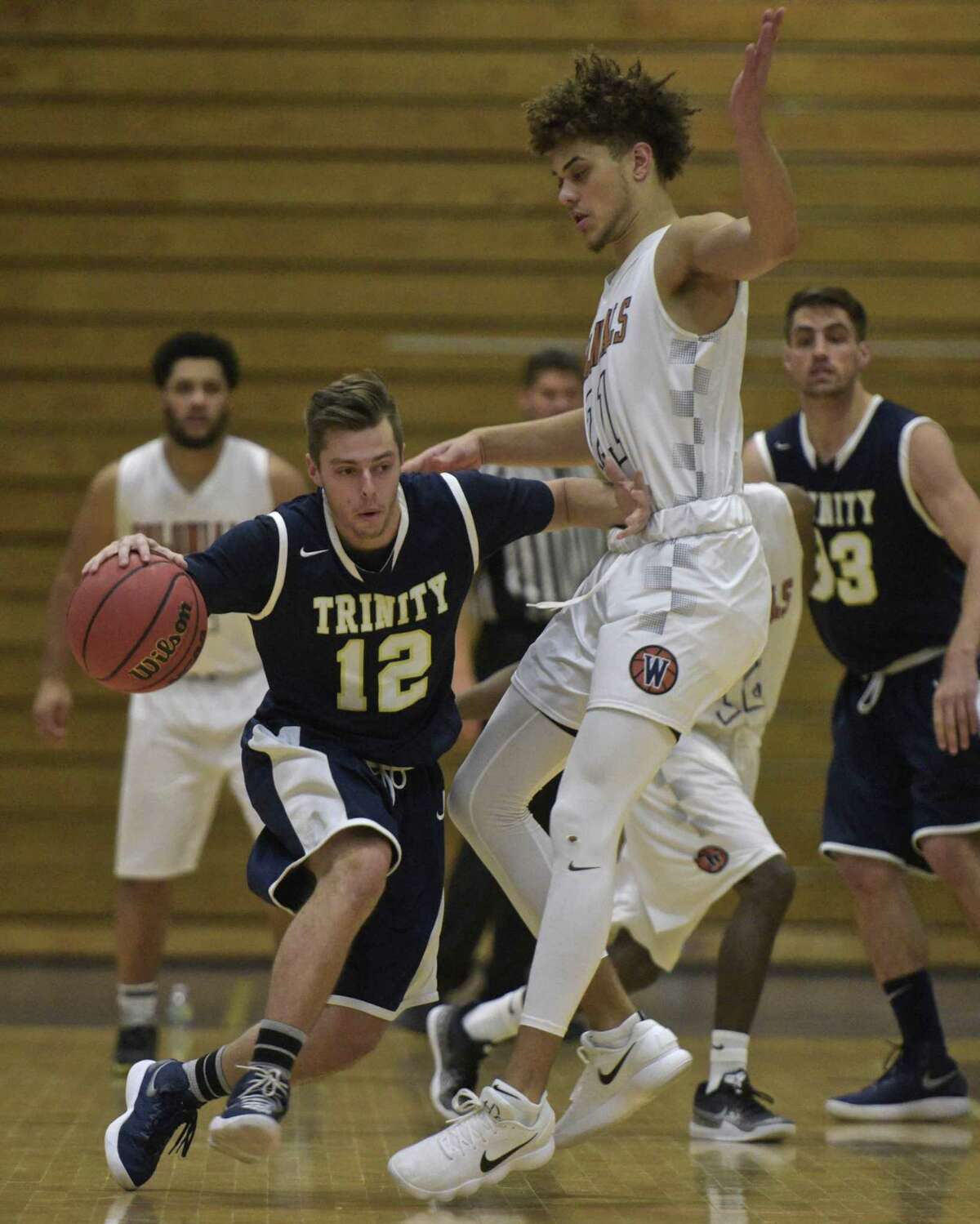 Trinity's Christian Porydzy (12) tries to go through Westconn's Fenton Bradley Jr (21) in the Men's basketball game between Trinity College and Western Connecticut State University on Thursday night, November 30, 2017, at the O'Neil Center-Feldman Arena, Westside Campus of WCSU, in Danbury, Conn.