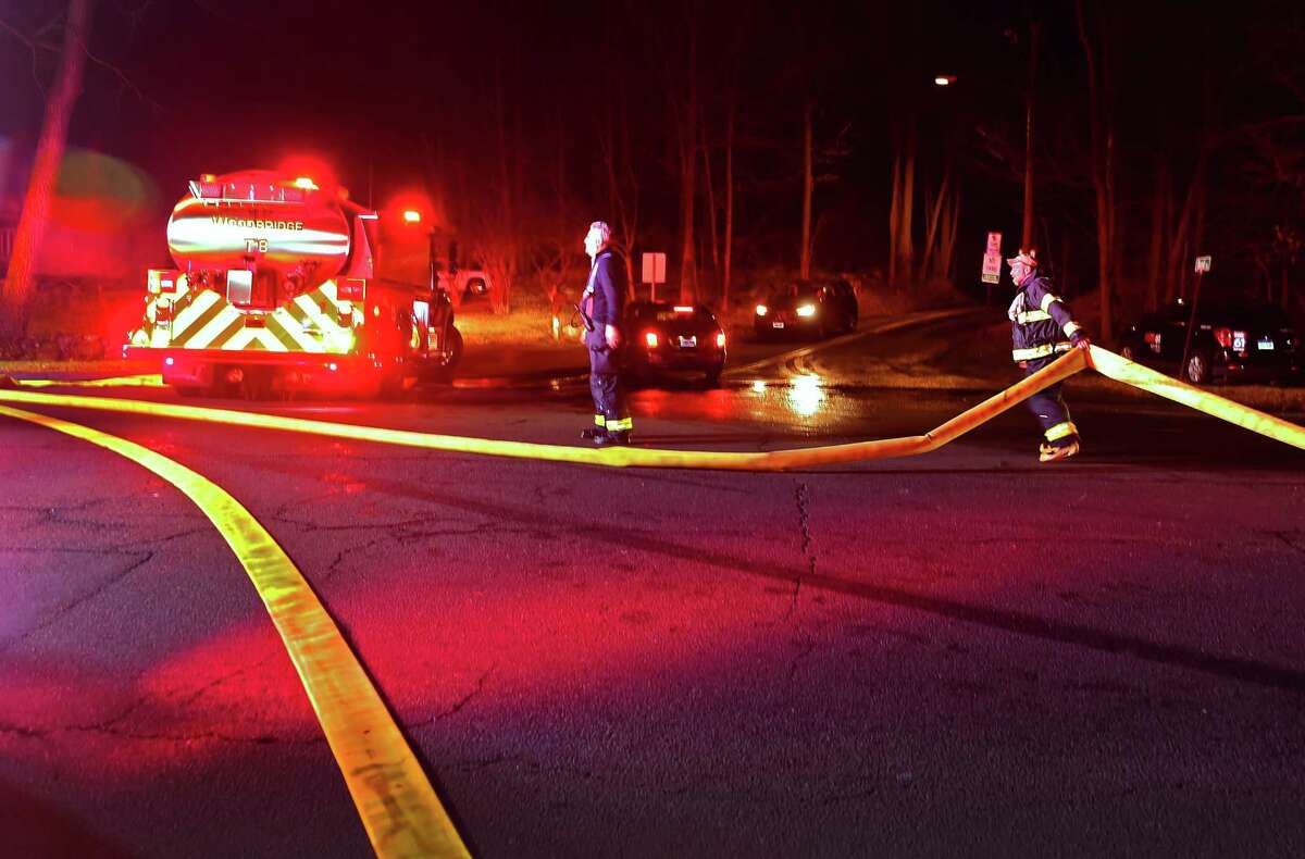 (Peter Hvizdak - New Haven Register) Firefighters on Route 63 and Bond Road in Woodbridge near the roadway entrance to the fire at the Jewish Community Center Monday evening , December 5, 2016