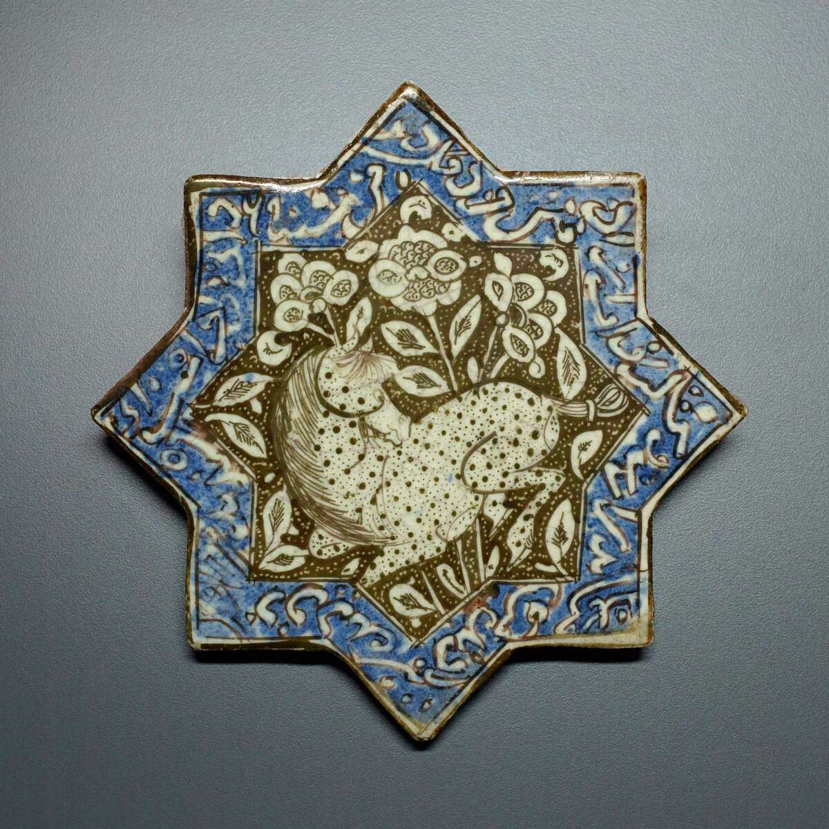 Calligraphy borders a 13th-century star tile from Iran, one of many intricate items in "Bestowing Beauty" at the Museum of Fine Arts, Houston.