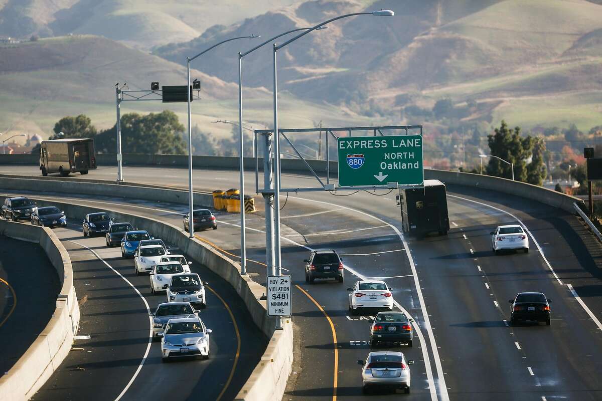 Morning commuters drive south passing a sign for an express lane on the Highway 237-880 interchange in Milpitas, Calif., on Monday, Nov. 27, 2017.