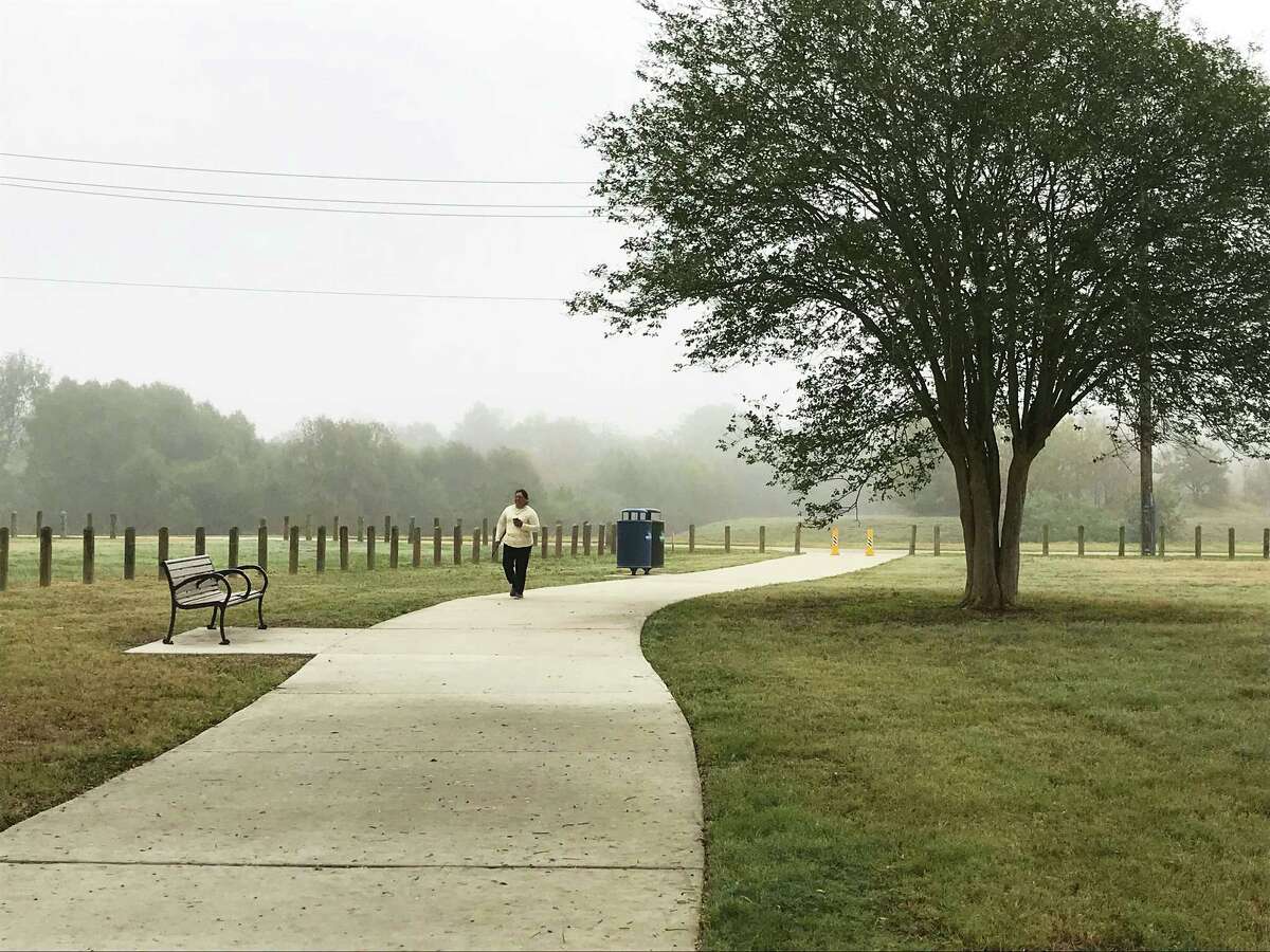 Maria Gomez strolls along a path created by the Houston Parks Board across a new green space that was formerly the site of the crime-ridden, abandoned Oakbrook Apartments on De Soto Street in northwest Houston.