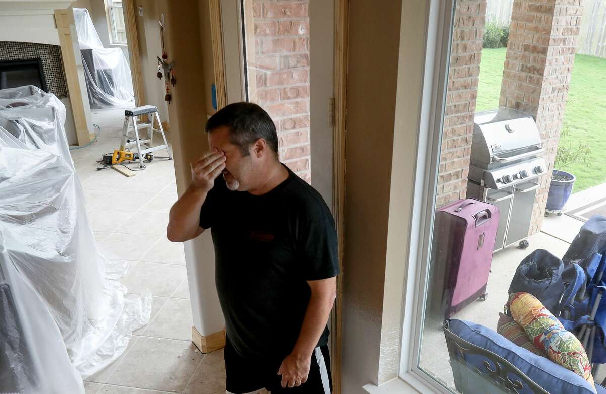 Scott Dorman, who moved from Connecticut with his wife, rubs his face as he talks about damage from Hurricane Harvey, in Riverstone. Dorman's house backs up to a levee. "When I moved here, people said at least you don't have to shovel snow," Dorman said. "But, you can't shovel water."