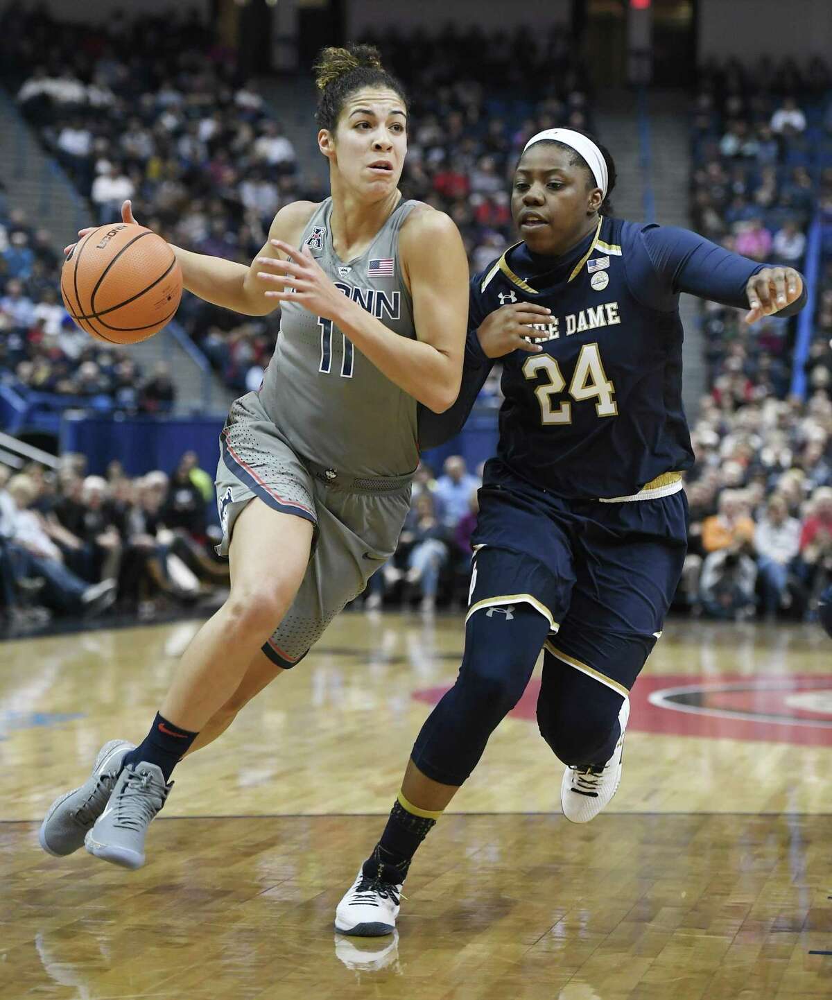 UConn’s Kia Nurse dribbles as Notre Dame's Arike Ogunbowale defends during the first half Sunday in Hartford.