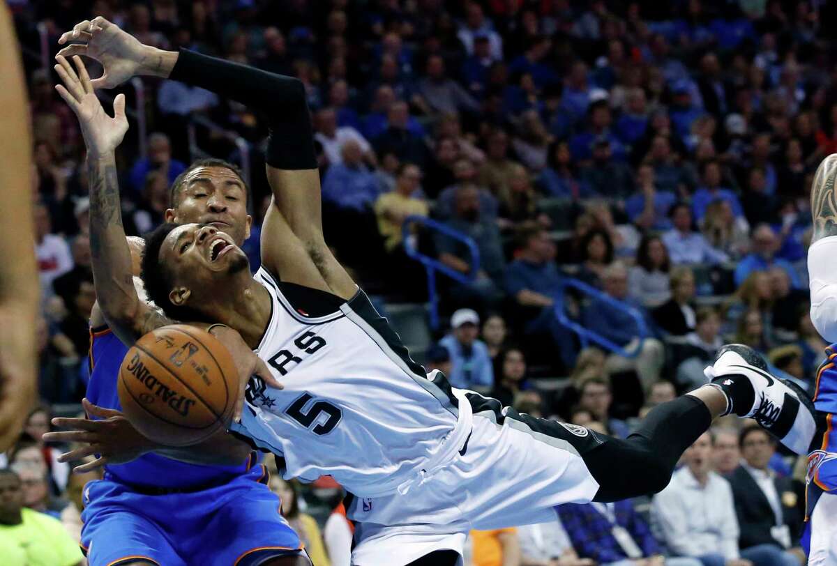 San Antonio Spurs guard Dejounte Murray (5) loses the ball in front of Oklahoma City Thunder guard Josh Huestis in the first half of an NBA basketball game in Oklahoma City, Saturday, March 10, 2018. (AP Photo/Sue Ogrocki)