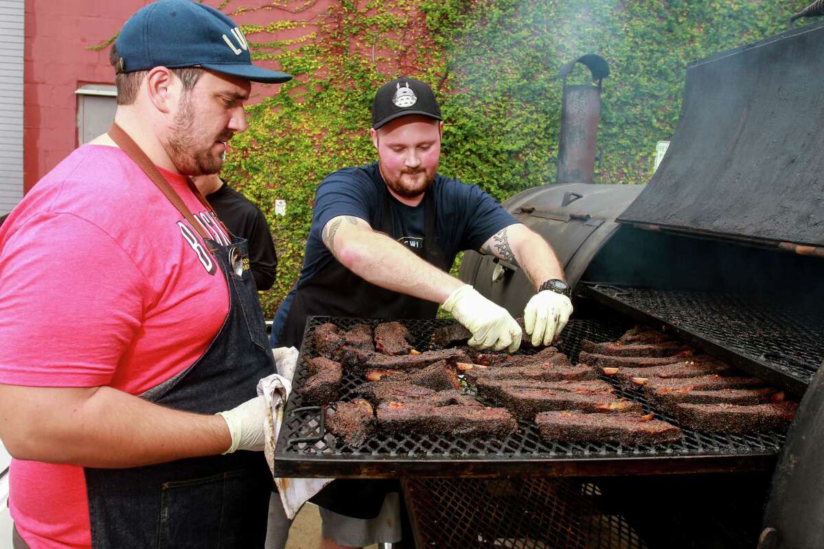 Evan LeRoy, left, and Gabe Golub of LeRoy and Lewis Barbecue, removing ribs at the HOU-ATX BBQ Throwdown at the Saint Arnold Brewing Co.