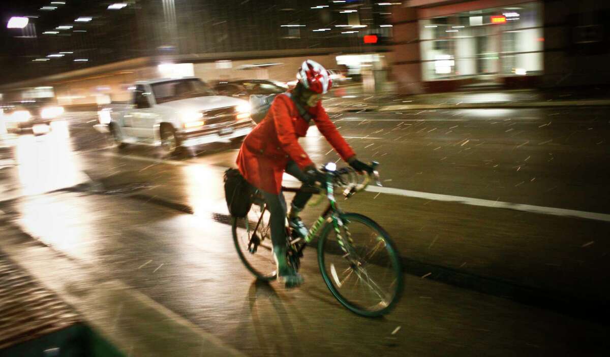 A bike rider navigates the streets during the unseasonable snow fall in downtown Houston, TX Wednesday, Dec. 10, 2008.