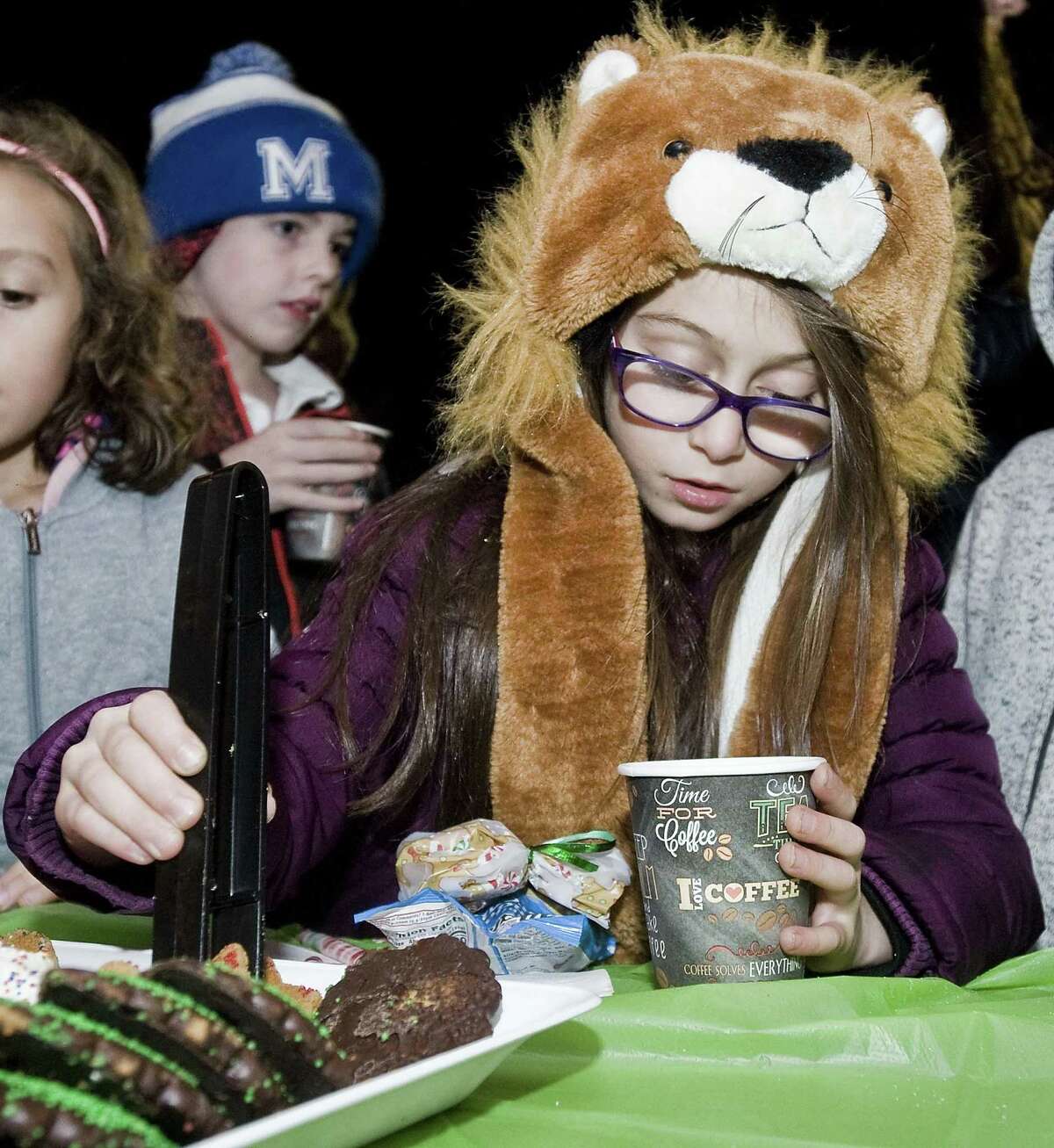 Eliana Kitmiridis, 7 of Norwalk, fills her cup with cookies at the tree lighting at Roger Ludlow Triangle. Sunday, Dec. 3, 2017