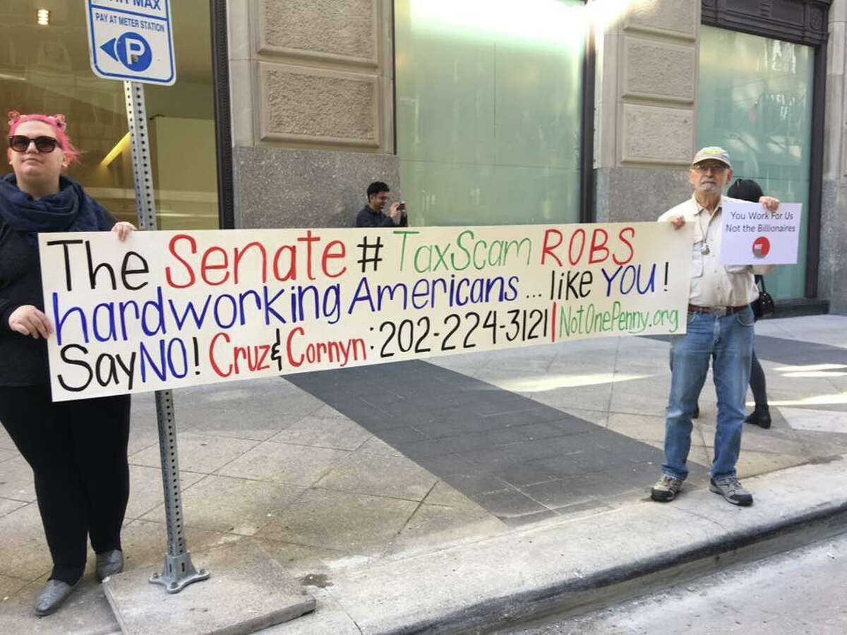A number of organizations, including Indivisible Houston, rally together outside Ted Cruz's office Monday in part of a Nation Day of Action at Senate offices across the country to reject the Senate Tax Bill.
