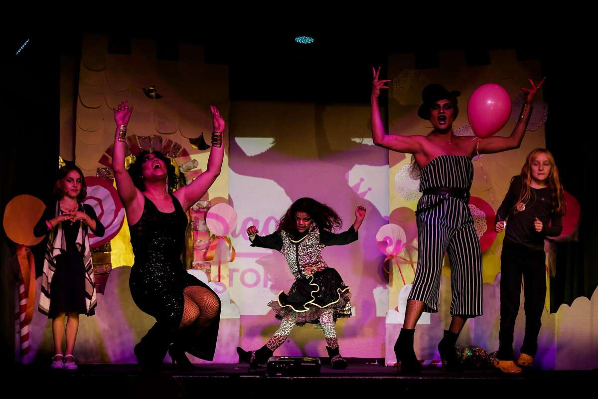 A person who goes by Yves Saint Croissant (second from left), a child who went by "the sneaky leopard kitten", 7 (center) and a person who went by Persia (second from right) dance during an event called, "We Are All Queens," at in San Francisco, Calif., on Sunday, Dec. 3, 2017. The event invited children to come use their imaginations and dress up.