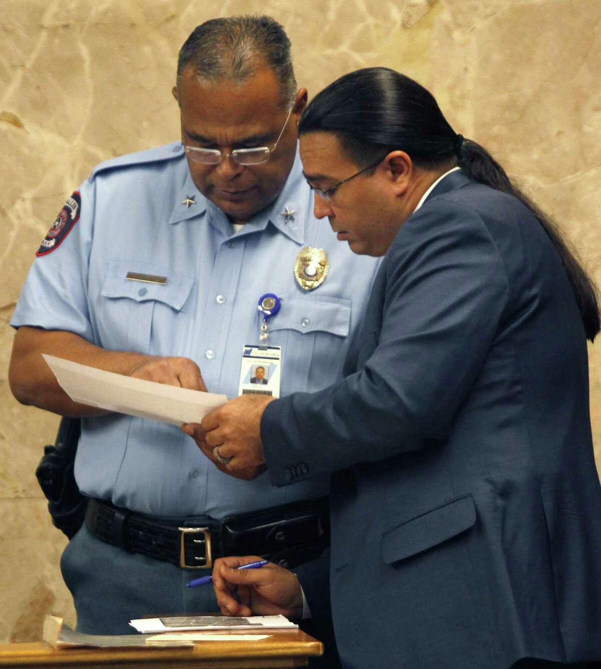 Defense attorney O. Rene Flores (right) talks with McAllen Police Chief Victor Rodriguez during a break in testimony Monday in John Feit’s trial for the 1960 murder of Irene Garza in the 92nd state District Court at the Hidalgo County Courthouse in Edinburg.