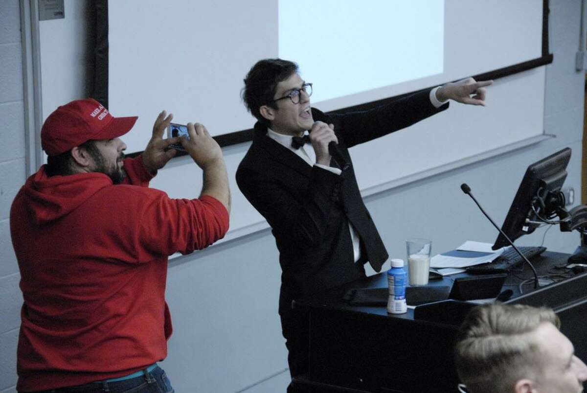 In this Nov. 28, 2017 photo, Lucian Wintrich, White House correspondent for the right-wing blog Gateway Pundit, speaks at the University of Connecticut in Storrs, Conn. while being photographed by Salvatore “Sal” Cipolla. The conservative commentator was arrested and charged with breach of peace after an altercation during his speech titled "It's OK To Be White." (Rebecca Lurye/The Courant via AP)