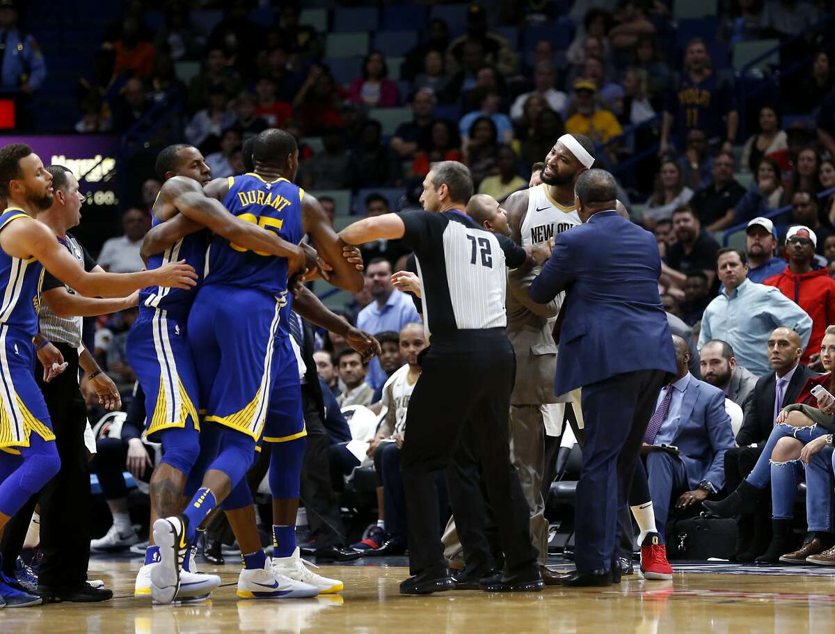 Golden State Warriors forward Kevin Durant and New Orleans Pelicans center DeMarcus Cousins (0) are restrained while going after each other during a scuffle in the second half of an NBA basketball game in New Orleans, Monday, Dec. 4, 2017. Both players were ejected from the game, and the Warriors won 125-115.