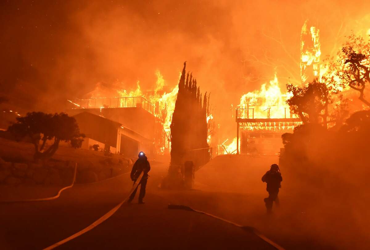 In this photo provided by the Ventura County Fire Department, firefighters work to put out a blaze burning homes early Tuesday, Dec. 5, 2017, in Ventura, Calif. Authorities said the blaze broke out Monday and grew wildly in the hours that followed, consuming vegetation that hasn't burned in decades. (Ryan Cullom/Ventura County Fire Department via AP)