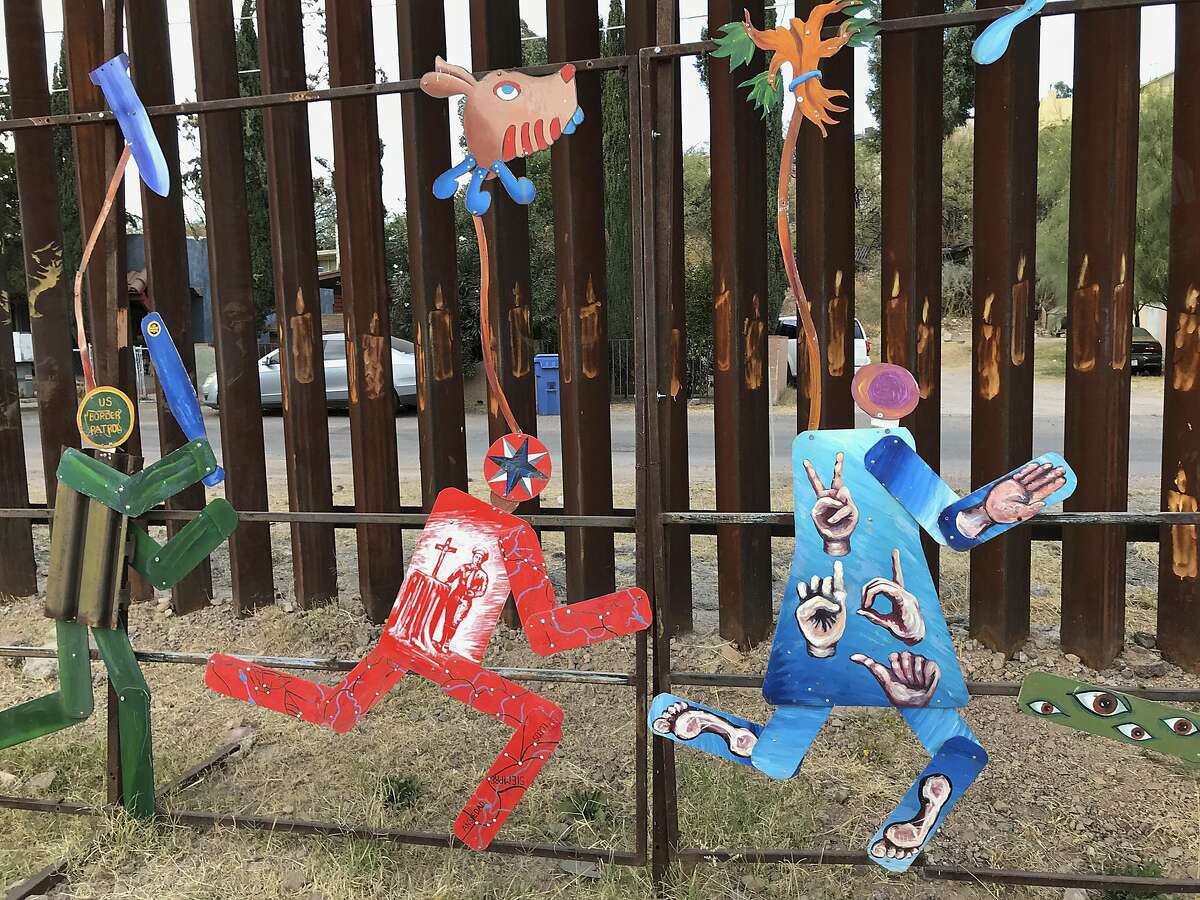 This photo taken Monday, Dec. 4, 2017, shows the international boundary with the United States decorated with colorful public art that protests immigration policies in Nogales Mexico. The figures portray a U.S. Border Patrol officer chasing several migrants. The federal government on Tuesday, Dec. 5, 2017, issued its most complete statistical snapshot of immigration enforcement under President Donald Trump, saying Border Patrol arrests plunged to a 45-year low while arrests by deportation officers soared. (AP Photo/Anita Snow)