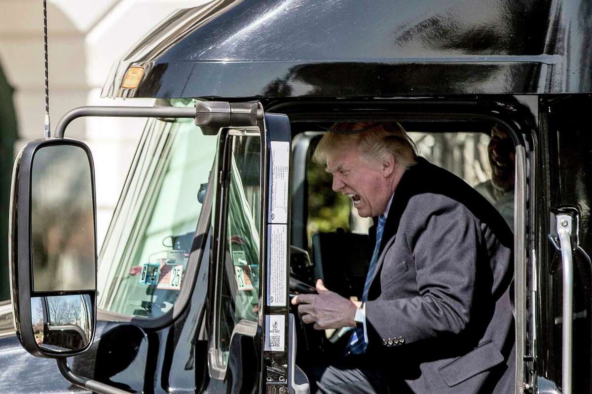 President Donald Trump pretends to drive as he gets in an 18-wheeler as he meets with truckers and CEOs regarding healthcare on the South Lawn of the White House, Thursday, March 23, 2017, in Washington. (AP Photo/Andrew Harnik)