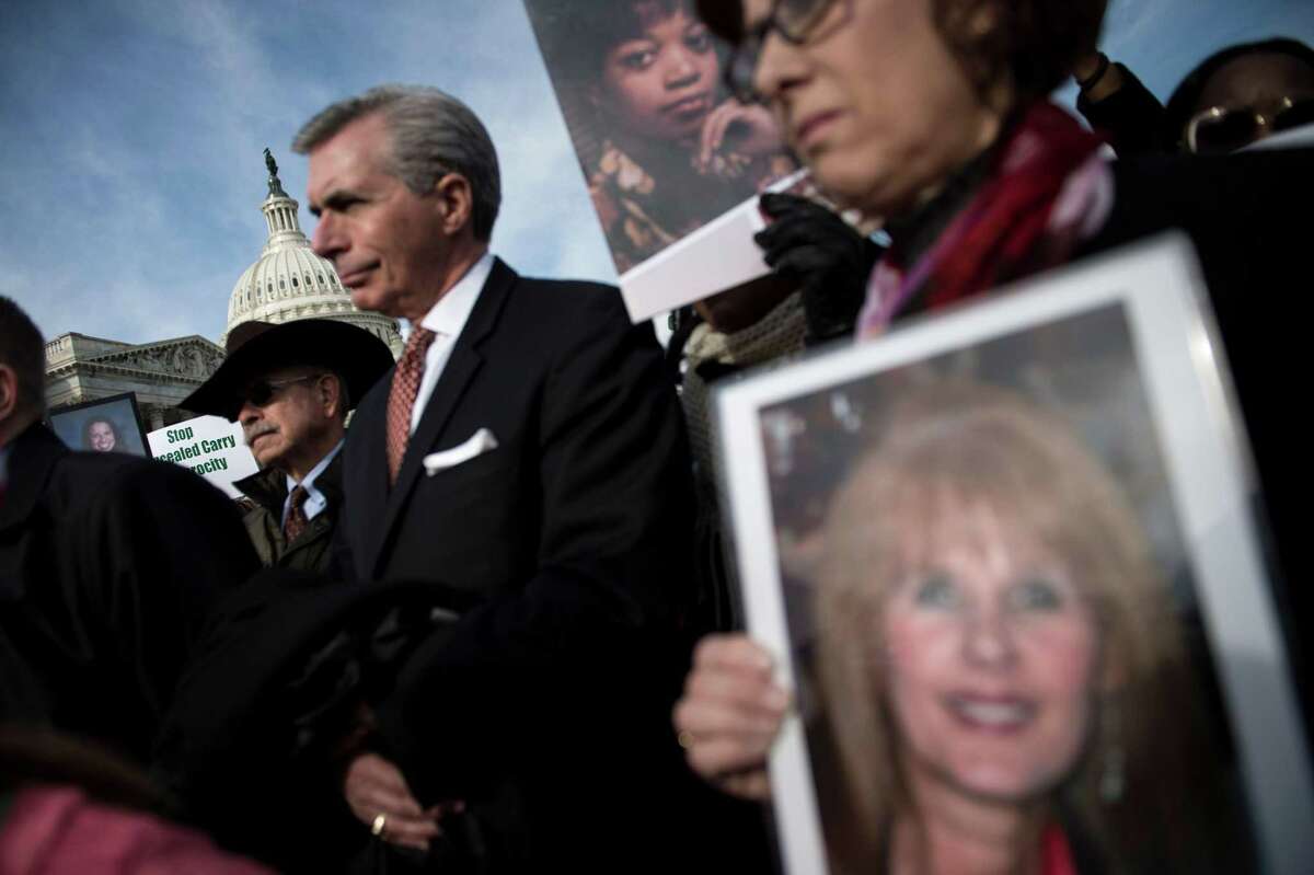 Jane Dougherty, right, holds up picture of her sister, Sandy Hook Elementary School psychologist Mary Sherlach, at an event on Capitol Hill opposing concealed carrying of guns December 6, 2017 in Washington, DC. US lawmakers were expected to vote Wednesday to let gun owners carry concealed firearms across state lines, a controversial bill that critics say is aimed at undermining national gun control efforts.