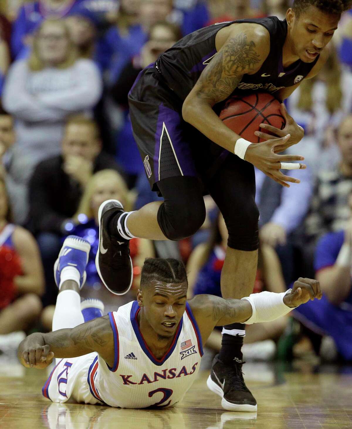 Washington's Hameir Wright beats Kansas' Lagerald Vick (2) to a loose ball during the first half of an NCAA college basketball game Wednesday, Dec. 6, 2017, in Kansas City, Mo. (AP Photo/Charlie Riedel) ORG XMIT: MOCR110