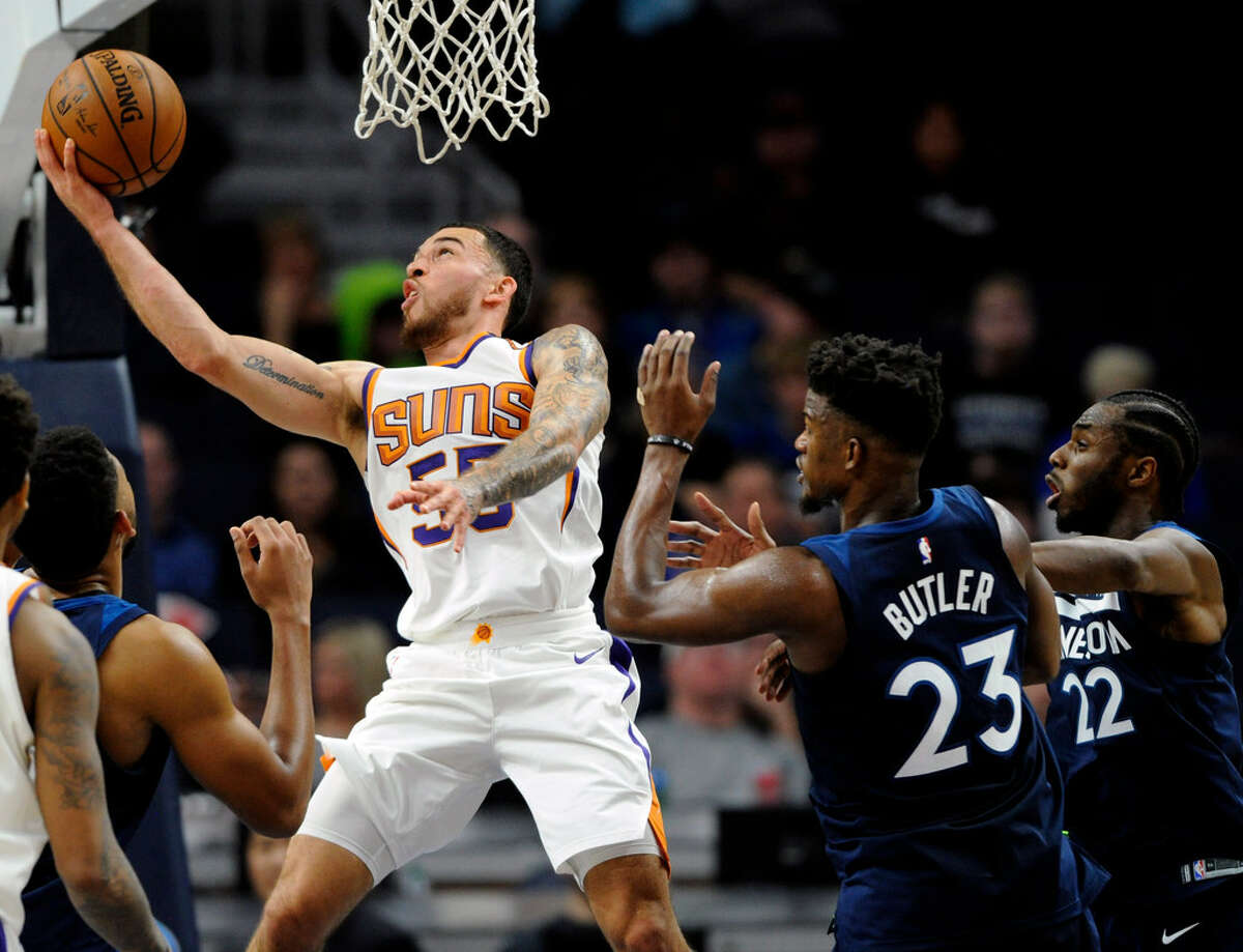 Phoenix Suns' Mike James (55) shoots against center Minnesota Timberwolves' Jimmy Butler (23) and Andrew Wiggins (22) during the fourth quarter of an NBA basketball game on Sunday, Nov. 26, 2017, in Minneapolis. The Timberwolves won 119-108. (AP Photo/Hannah Foslien)