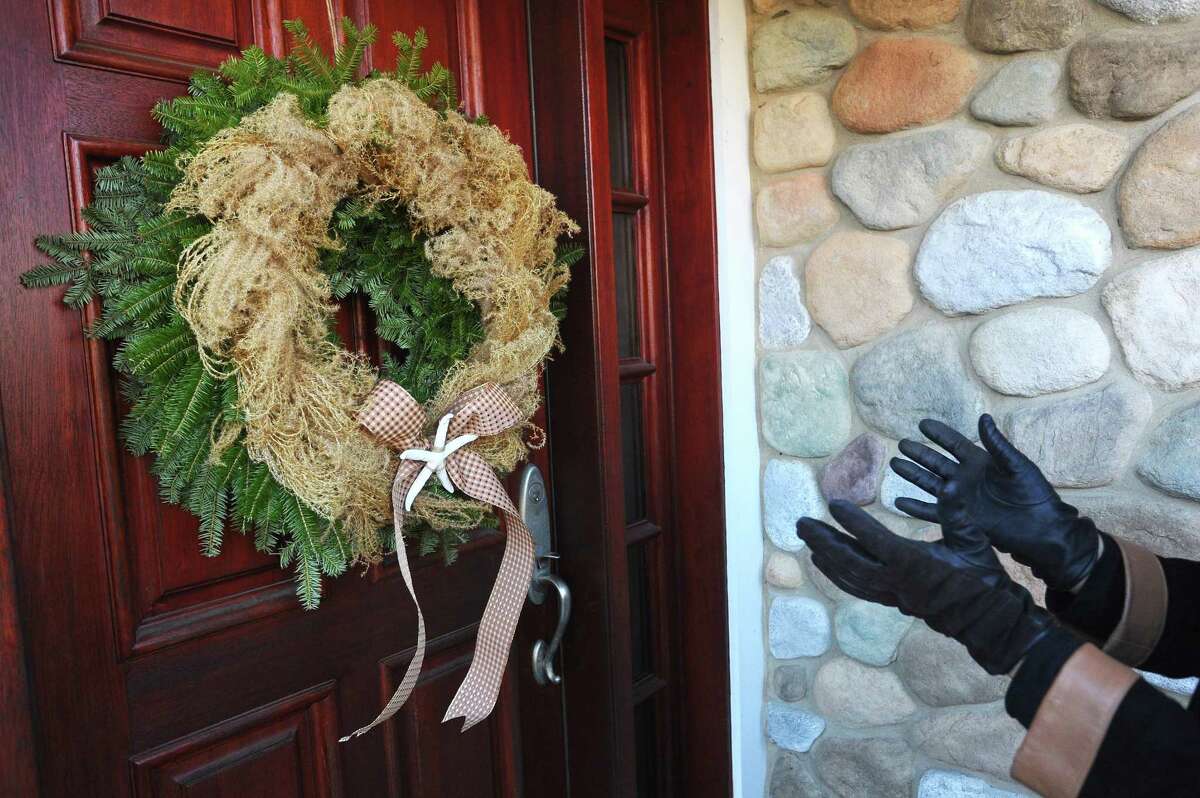 Judge Rusty Ruth talks about what she likes and dislikes about Donna Wiberg's wreath while judging the newcomer category of the annual Doors of Shippan on Ocean Drive North in Stamford, Conn. on Thursday, Dec. 7, 2017.
