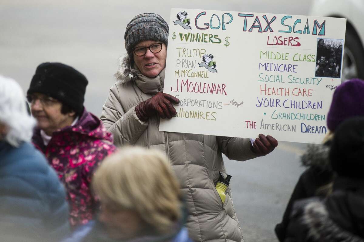 A group walks to U.S. Rep. John Moolenaar's Midland office during a protest of the GOP tax plan on Thursday, Dec. 7, 2017. (Katy Kildee/kkildee@mdn.net)
