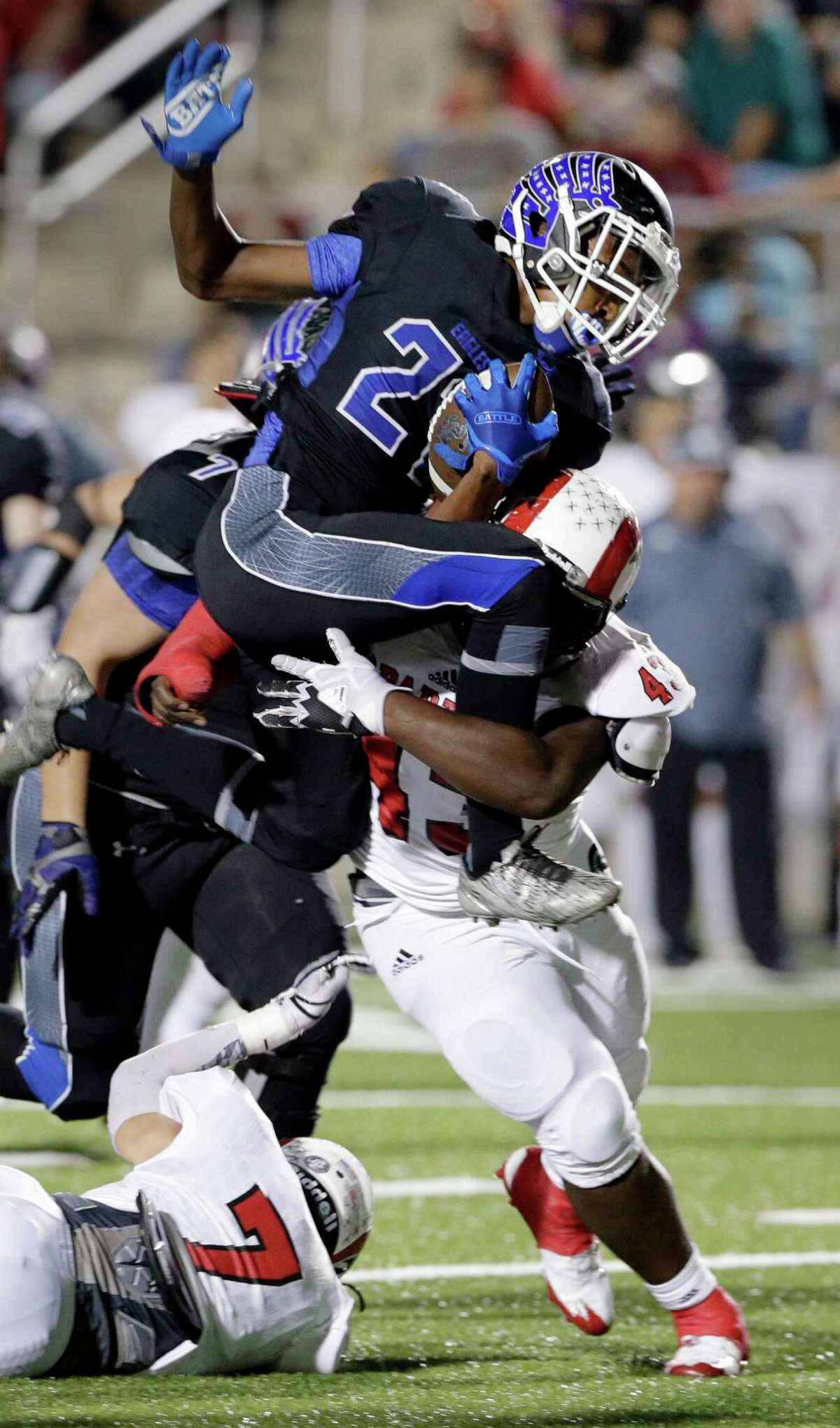 New Caney's C.J. Sanders (21) jumps to avoid the tackle by Porter's Gage Royse (7) and Jordan Lewis (43) in the first half of their game, Nov. 3, 2017, in Porter, TX. (Michael Wyke / For the Chronicle)