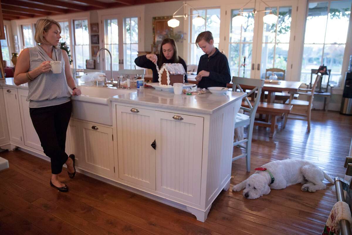 Sonya Sweeney who lost her home during the recent firestorm, looks on after serving breakfast as her son Nicky, 12, and daughter Maddie, 15, make a gingerbread house for a fund raiser at their temporary residents, a friend of the families winery second home, as the wait to move in to their recently purchased house in Sebastopol, in Santa Rosa, California, USA 7 Dec 2017.