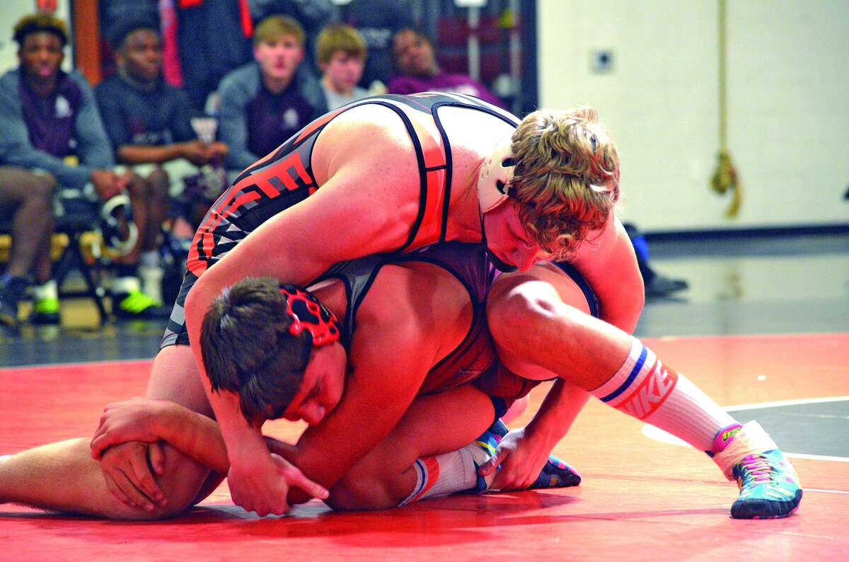 Edwardsville junior Sam Martin, top, tries to get a hold on Belleville West’s Riley Elam in a 195-pound match during Thursday’s Southwestern Conference match at Jon Davis Wrestling Center.