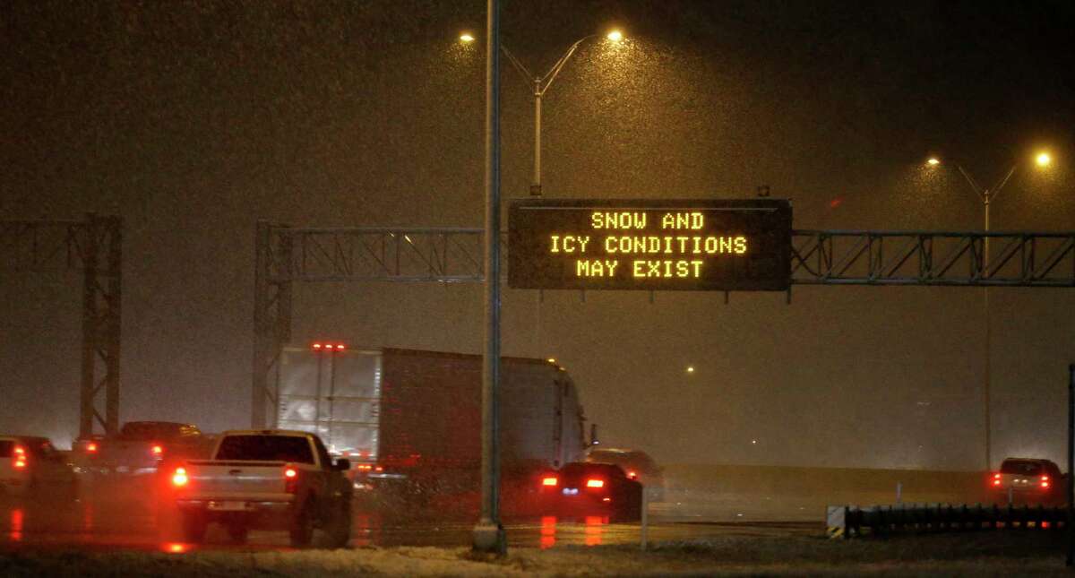 FILE — Motorist drive on IH-10 East as a snow storm moves through the San Antonio area Thursday, Dec. 7, 2017. Light snow may fall in South and Central Texas between late Monday night and Tuesday evening, coupled with freezing rain and sleet, according to a National Weather Service alert.