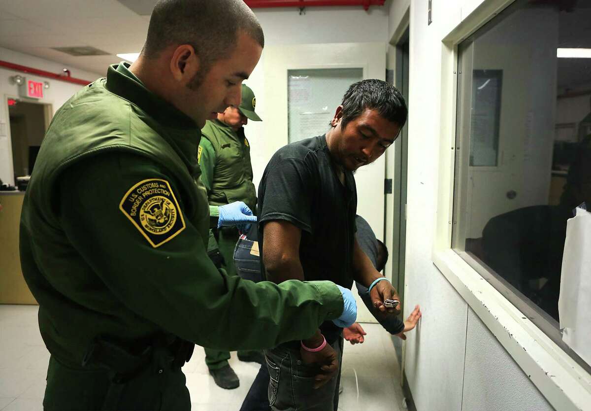 Border Patrol agent Ben Giroux, left, processes a man from Mexico in the Marfa office in the Big Bend Sector, which includes Van Horn where Rogelio Martinez worked and died while on patrol.