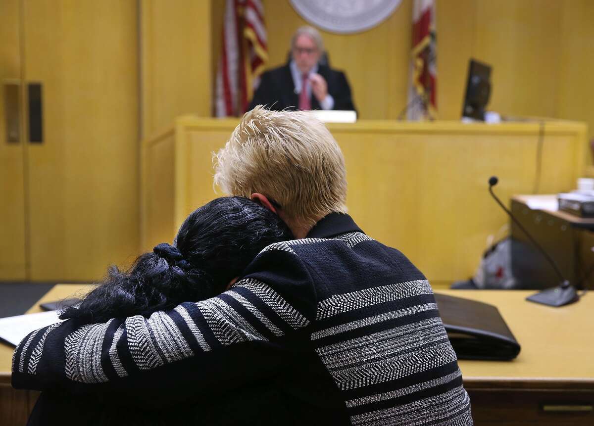 Danielle Bologna is hugged by family friend Marti McKee (right) after reading a personal statement in front of Superior Court Judge Brendan Conroy before he sentences Wilfredo Reyes to 10 years in prison in San Francisco, Calif. on Friday, July 10, 2015 for his role in the 2008 murder of Bologna's husband Anthony Bologna and their two sons Matthew and Michael in a case of mistaken identity.
