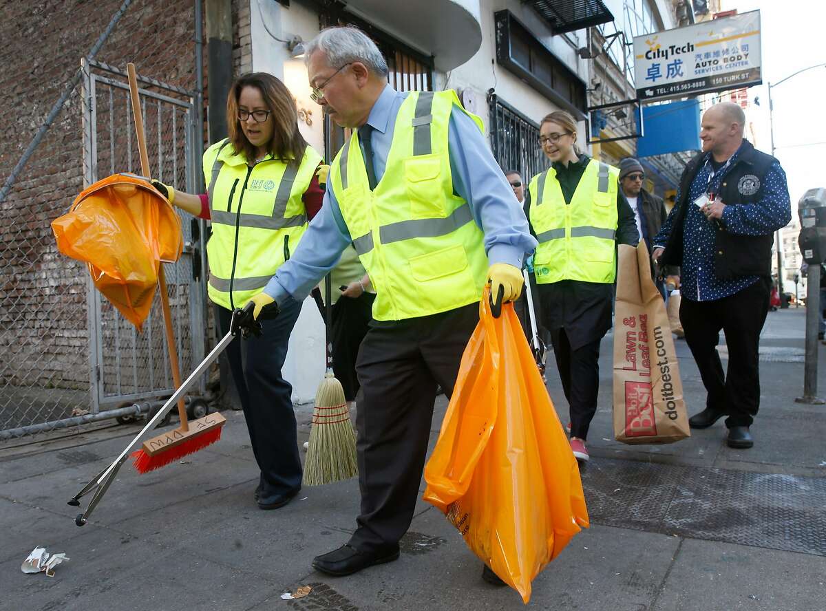Mayor Ed Lee pitches in to help his multi agency Fix-It Team clean up Tenderloin sidewalks. The Fix-It Team carries a container for needles.