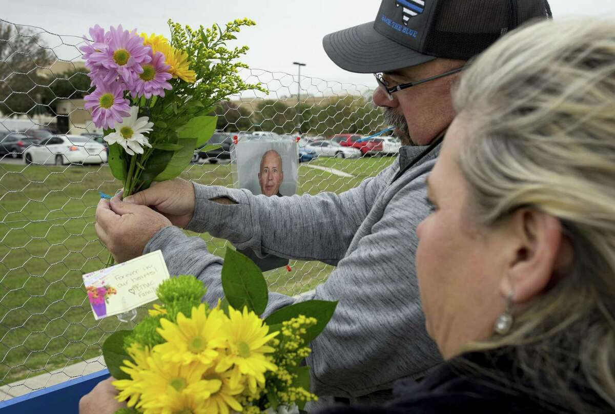 Kathleen and Chris Chomel put flowers on a memorial for slain San Marcos police officer Kenneth Copeland at Central Texas Medical Center in San Marcos, Texas, on Tuesday Dec. 5, 2017, the day after he was killed attempting to serve a warrant. (Jay Janner/Austin American-Statesman via AP)