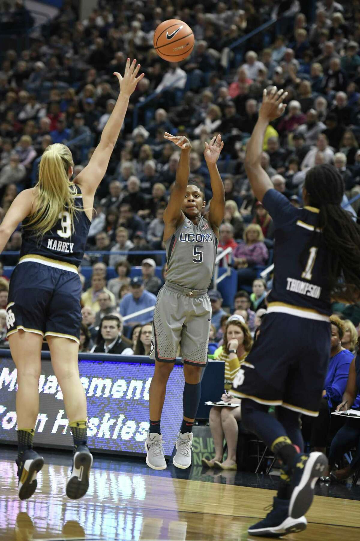 UConn’s Crystal Dangerfield shoots between Notre Dame defenders Marina Mabrey, left, and Lili Thompson on Dec. 3.